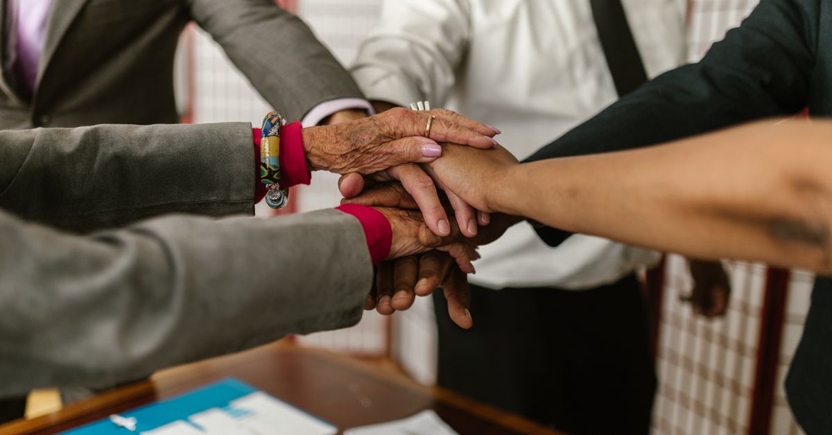 A diverse group of businesspeople uniting their hands symbolizing teamwork and cooperation.